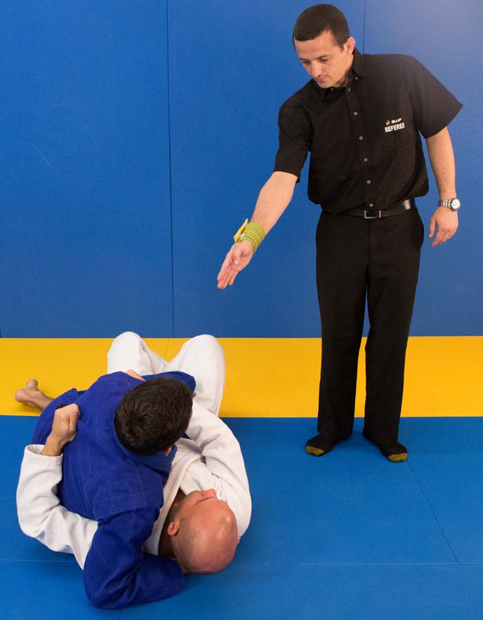 Referee signal for penalty while standing - pointing to athlete's chest