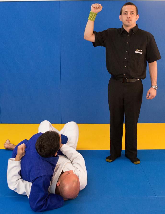 Referee signal for penalty while standing - clenched fist raised to shoulder height